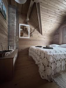 GinučiųTrainiškio pirkia的木制客房内的一间卧室,配有一张床