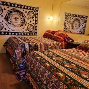 坎普维德Stargazing Retreats的酒店客房设有三张床,配有色彩缤纷的毯子