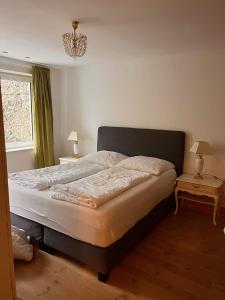 汉堡FeWo Parkblick HH Schanze的卧室内的一张床位,配有两张桌子和吊灯
