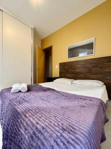 贝洛奥里藏特LK GRAJAÚ 1的一间卧室配有一张紫色床和两条毛巾