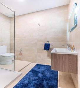 瓦莱塔Sea View Luxury Apartment Brand New in Valletta的设有带水槽和卫生间的浴室以及蓝色地毯。