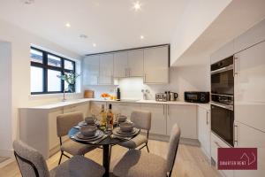 沃金厄姆Modern 3 Bedroom Apartment - Wokingham的厨房以及带桌椅的用餐室。