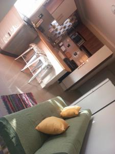 鲸湾港TALITHA'S SELF-CATERING ACCOMMODATION的客厅配有带两个枕头的绿色沙发