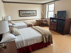 FennimoreFenway House Hotel的酒店客房设有两张床和一张桌子。