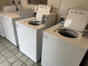 列治文山FairBridge Inn & Suites Richmond Hill的洗衣房配有3台洗衣机和烘干机