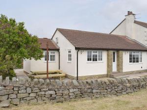 StaintondaleRudda Farm Cottage - Uk2492的前面有石墙的白色房子