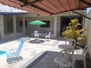 累西腓Sonho dos golfinhos的庭院配有桌椅和遮阳伞。