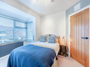 切斯特勒斯特里特25 Appledore Gardens的一间卧室配有一张带蓝色毯子的床和窗户。