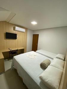 索里苏Hotel dos viajantes的卧室配有一张白色大床和一张书桌