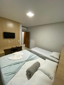 索里苏Hotel dos viajantes的酒店客房设有两张床和一台平面电视。