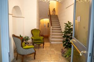 巴里CASA ALMIKA PRINCIPE AMEDEO的走廊设有两把椅子和一张桌子,还有楼梯