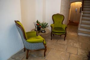 巴里CASA ALMIKA PRINCIPE AMEDEO的两张绿色椅子和一张桌子