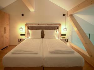 比特亨巴赫布肯巴真霍夫酒店的卧室配有一张带两个枕头的大白色床