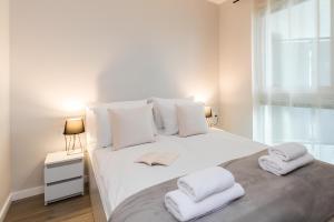 詹塔尔Flatbook Apartamenty - Jantar Resort的卧室配有白色床和毛巾