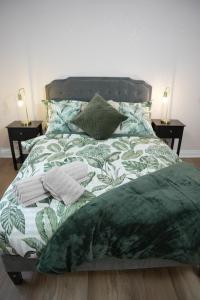 德比Stylish Pride Park DERBY Apartment - Free WIFI, Parking的一张带绿色和白色棉被和枕头的床