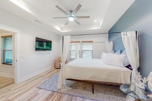 巴拿马城海滩Driftwood Dreams的一间卧室配有一张床和吊扇