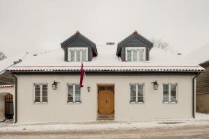 采西斯Spīdalas nams的一间白色的房子,设有棕色的门