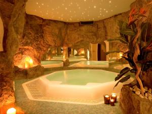 维拉奥通Hotel Foestlerhof的石头房的热水浴池,带蜡烛