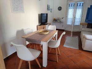 卡拉古诺内Appartamento Sole的客厅配有木桌和白色椅子
