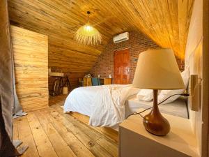 阿鲁沙Home Villa Arusha的一间卧室配有一张床和一张桌子上的台灯