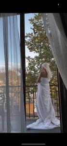 敖德萨德利巴斯酒店的坐在窗户上的穿着婚纱的女人