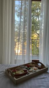 敖德萨德利巴斯酒店的窗前床上的托盘食物