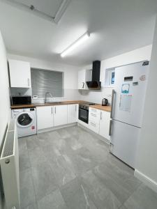 CanleyCloud Green apartment的厨房配有白色橱柜和白色冰箱。