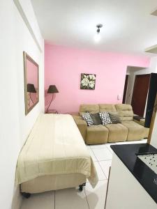 波苏斯-迪卡尔达斯Apartamento Aconchegante Centro de Poços de Caldas的客厅配有床和沙发