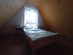韦莱姆Pele vendégház的木制客房的一张床位,设有窗户