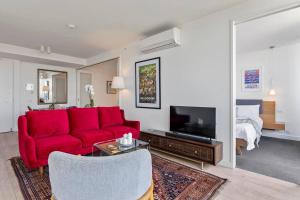 墨尔本Iconic Melbourne的客厅配有红色沙发和电视