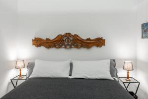 博洛尼亚Art Apartment Galliera的一间卧室配有一张带两盏灯的床