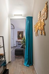 博洛尼亚Art Apartment Galliera的客厅配有蓝色窗帘和沙发