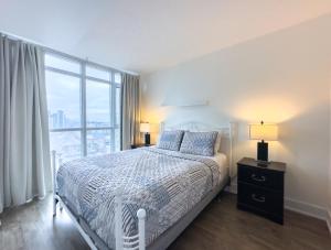 多伦多300 Front Suites - Two Beds with Free Parking的一间卧室设有一张床和一个大窗户
