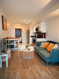 多伦多300 Front Suites - Two Beds with Free Parking的一间带蓝色沙发的客厅和一间厨房