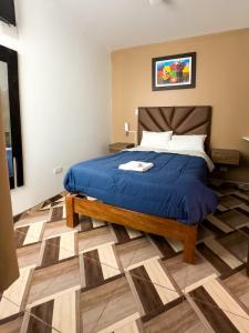 卡哈马卡HOTEL NILA的一间卧室配有一张带蓝色棉被的床