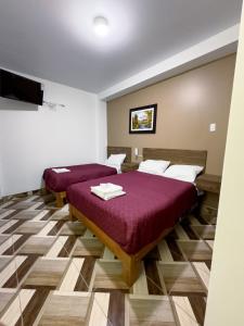 卡哈马卡HOTEL NILA的客房设有两张床和一台平面电视。