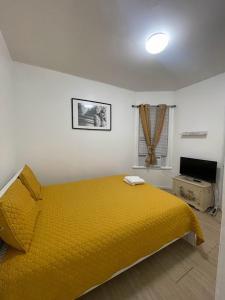 帕特森SUITE Dreams CARROLL 11的一间卧室配有黄色的床和电视