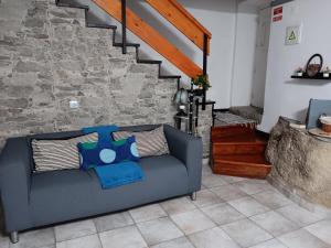 利尼亚雷斯Recanto da Pedra的客厅设有蓝色的沙发,客厅设有石墙