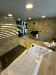 波哥大Hotel Joy Cll 85的带浴缸和卫生间的大型浴室