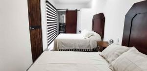 Cuatrociénegas de CarranzaVagón Resort的一间卧室配有两张床和镜子