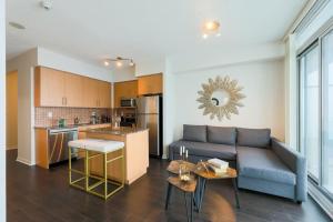 多伦多Skyline Elegance Condo的带沙发的客厅和厨房