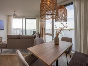 阿讷默伊登Spacious waterfront apartment的客厅配有桌子和沙发