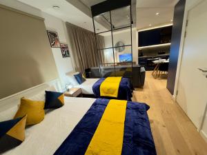 伦敦Amazing Cosy Apartment, Next to O2 Arena and close to London Excel, Secure Parking的酒店客房带两张黄色和蓝色的床