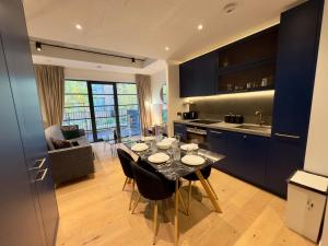伦敦Amazing Cosy Apartment, Next to O2 Arena and close to London Excel, Secure Parking的厨房以及带桌椅的用餐室。