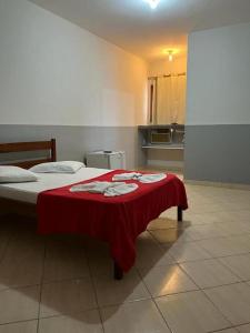 瓜拉派瑞Hotel Pousada Em Guarapari - Pousada Paraiso的一间卧室配有一张床铺,床上铺有红色毯子