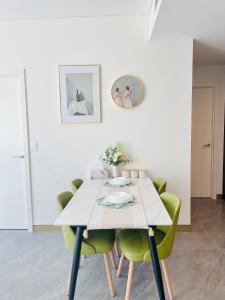 悉尼Modern Apartment St Leonards的一张餐桌,配有绿椅