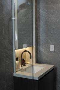 悉尼Modern Apartment St Leonards的一间带水槽和镜子的浴室