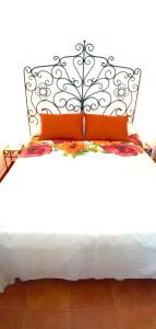AlomartesEl Mirador de Pablo, casa con patio privado的一张带黑白床头板和橙色枕头的床