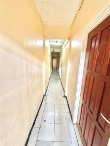 帕拉马里博Hotel Mangueira的一条空的走廊,有门,铺着瓷砖地板
