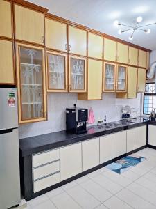 居銮23 Sri Kluang HomeStay - Up to 15pax的厨房配有白色橱柜和黑色台面